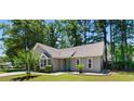 Inviting home with a manicured lawn, complemented by mature trees and a delightful turquoise front door at 250 Nature Trail, Little River, SC 29566