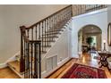 Elegant entryway featuring a staircase with metal balusters, hardwood floors, and arched doorway leading to living spaces at 2790 Fowler Rd., Loris, SC 29569