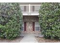 Close up of a charming condominium entrance with brick and white trimmed balcony above at 3676 Clay Pond Village Ln. # 4, Myrtle Beach, SC 29579
