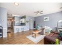 Open-concept living room with a ceiling fan, hardwood floors, and neutral-colored walls at 3939 Gladiola Ct. # 202, Myrtle Beach, SC 29588