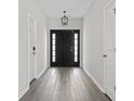 Hallway featuring a stylish front door with sidelights and wood-look flooring, creating a welcoming atmosphere at 417 Grain Field Dr., Georgetown, SC 29440