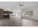 Spacious living room open to the kitchen, featuring neutral walls, wood floors, and large windows at 417 Grain Field Dr., Georgetown, SC 29440