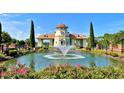 Picturesque view of a charming pond with a fountain, surrounded by vibrant pink flowers and manicured greenery at 419 Starlit Way, Myrtle Beach, SC 29579