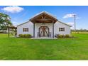 Spacious white barn featuring a covered porch, decorative front doors, and manicured lawn at 4499 Highway 308, Aynor, SC 29544