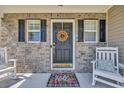 Inviting front door with brick, black shutters, rocking chairs, and fall wreath at 4501 Farm Lake Dr., Myrtle Beach, SC 29579