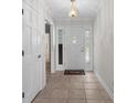 Bright foyer featuring decorative glass door inserts, neutral tile floors, and elegant chandelier at 578 Circle Dr., Myrtle Beach, SC 29575