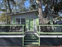 Inviting home with green accents, a spacious front deck and a tree growing through at 6001-Z67 S Kings Hwy., Myrtle Beach, SC 29575