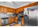 Well lit kitchen with stainless steel appliances, gray backsplash, and wooden cabinets at 6309 N Ocean Blvd. # 14 E, North Myrtle Beach, SC 29582