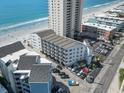 Elevated exterior view showcasing a multi-story building near the ocean and featuring private parking at 920 N Waccamaw Dr. # 2102, Murrells Inlet, SC 29576