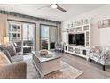 Cozy living room with a comfortable couch, a TV, and sliding doors to a private balcony at 920 N Waccamaw Dr. # 2102, Murrells Inlet, SC 29576