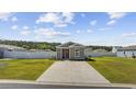 Wide view of a charming single-story home with landscaped yard, long concrete driveway and white fence at 924 Akron St., Conway, SC 29526