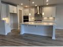 Modern kitchen features white cabinets, stainless steel appliances, and a large center island at 9409 Long Meadow Way, Longs, SC 29568