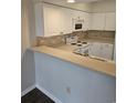 White kitchen cabinets with gray countertops and tile backsplash at 102 Scotch Broom Dr. # B-204, Little River, NC 29566