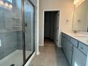 Bathroom with a glass shower, double vanity, and neutral-toned tile at 1232 Lady Bird Way, North Myrtle Beach, SC 29582