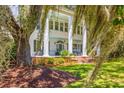 Elegant two-story home with a welcoming front porch, stately white columns, and beautiful greenery at 21 Whitehall Ave., Georgetown, SC 29440