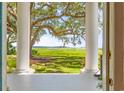 Scenic view from the porch showcasing the lush green lawn with mature tree to the scenic waterway beyond at 21 Whitehall Ave., Georgetown, SC 29440