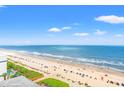 Expansive ocean view, featuring a sandy beach with blue umbrellas and a clear, sunny sky above the ocean at 2301 S Ocean Blvd. # 1418, Myrtle Beach, SC 29577