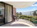 Balcony view with chairs overlooking beach, palm trees, and blue skies on a sunny day at 2500 N Ocean Blvd. # 102, Myrtle Beach, SC 29577