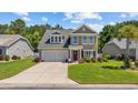Charming two-story home featuring a well-maintained lawn, two car garage, and inviting front porch at 284 Whipple Run, Myrtle Beach, SC 29588