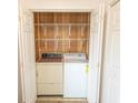 Laundry closet with washer, dryer, wire shelving, and wooden paneling behind folding doors at 305 N Hillside Dr. # 206, North Myrtle Beach, SC 29582