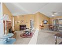 Spacious living room with a cozy fireplace, neutral carpet, and sunlit windows at 404 Snowy Egret Dr., Murrells Inlet, SC 29576