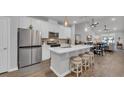 Modern kitchen with white cabinetry, stainless steel appliances, an island with stool seating and pendant lighting at 4053 Taranto Loop # C, Myrtle Beach, SC 29579