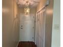 Hallway featuring a light fixture, hardwood floor, white entry door, and a closet with louvered doors at 5001 Little River Rd. # W-211, Myrtle Beach, SC 29577