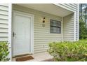 Welcoming entryway with a white door, a 'Welcome' mat, and a decorative exterior light fixture at 6703 Jefferson Pl. # B7, Myrtle Beach, SC 29572