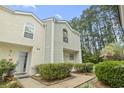 Inviting townhouse featuring a stucco exterior, a manicured lawn, and lush greenery at 6703 Jefferson Pl. # B7, Myrtle Beach, SC 29572