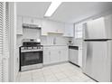 Bright kitchen with stainless steel appliances, white cabinets, and a hexagon tile backsplash at 6703 Jefferson Pl. # B7, Myrtle Beach, SC 29572
