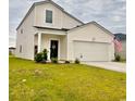Charming home with a welcoming front door and attached two-car garage, set against a cloudy sky at 8211 Forest Edge Dr., Myrtle Beach, SC 29579