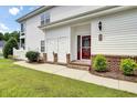 Welcoming entryway to townhome unit 53C, featuring a red door, brick accents, and well-kept landscaping at 8855 Radcliff Dr. Nw # 53C, Calabash, NC 28467