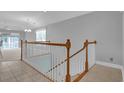 Bright stairway featuring tile flooring, white railings, and natural light from a nearby window at 8855 Radcliff Dr. Nw # 53D, Calabash, NC 28467