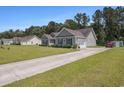 The home features a long driveway and an attached garage, complemented by a well-maintained lawn at 95 Timber Run Dr., Georgetown, SC 29440