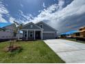 Well-manicured lawn of a blue-sided, single-story home with a two-car garage at 1241 Beeblossom Dr., North Myrtle Beach, SC 29582