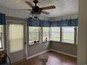 Cozy sun room with plenty of windows, tongue-and-groove paneling, and a ceiling fan at 125 Gavin Hill Ct., Aynor, SC 29511