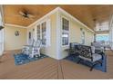 Inviting covered porch with comfortable seating, ceiling fan, and wood ceiling at 128 Lake Pointe Dr., Murrells Inlet, SC 29576