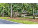 Side view of brick home featuring mature trees and a two-car garage at 15 Cherbourg Ct., Pawleys Island, SC 29585