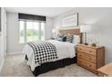 Cozy bedroom featuring a woven headboard, patterned bedding, and natural light from a large window at 2616 Elowen Ln. # 167B, Longs, SC 29568