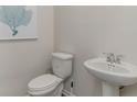 Cozy powder room with white fixtures, toilet, and decorative wall art at 2851 Riverboat Way, Conway, SC 29526