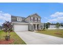 Charming two-story home with gray siding, shutters, a well-manicured lawn, and a welcoming front porch at 3129 Palma Way, Myrtle Beach, SC 29579