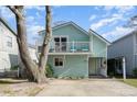 Charming, light blue, two-story home with a cozy front porch and a second-story balcony at 4307 Beverly Ct., North Myrtle Beach, SC 29582