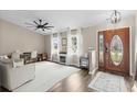 Bright and airy living room with hardwood floors, three windows and a stylish fireplace with white curtains at 4639 Mandi Ave., Little River, SC 29566