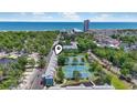 Aerial shot of the property including tennis courts and community pool with ocean view in the distance at 5905 South Kings Hwy. # 5202, Myrtle Beach, SC 29575