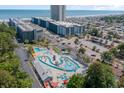 Aerial view of condo complex featuring lazy river, parking, and the ocean in the background at 5905 South Kings Hwy. # A518, Myrtle Beach, SC 29575