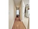Inviting hallway with neutral walls, wood-look floors, and a view of the door to the exterior at 665 Tupelo Ln. # 17-D, Longs, SC 29568