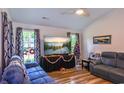Bright living room features hard wood floors, neutral paint, a ceiling fan, and large tv for entertaining at 67 Bossie Ln., Georgetown, SC 29440