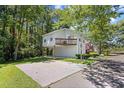 Two-story home featuring a covered garage, elevated deck, and ample parking space at 739 Tall Oaks Dr., Myrtle Beach, SC 29588
