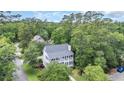 An aerial view of the property with surrounding lush trees and a glimpse of neighborhood at 9 Winnowing Way, Pawleys Island, SC 29585