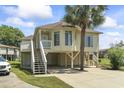 Beautiful raised beach home with stairs leading to a front porch and a convenient ground floor entrance at 914 Dock Pl., Murrells Inlet, SC 29576